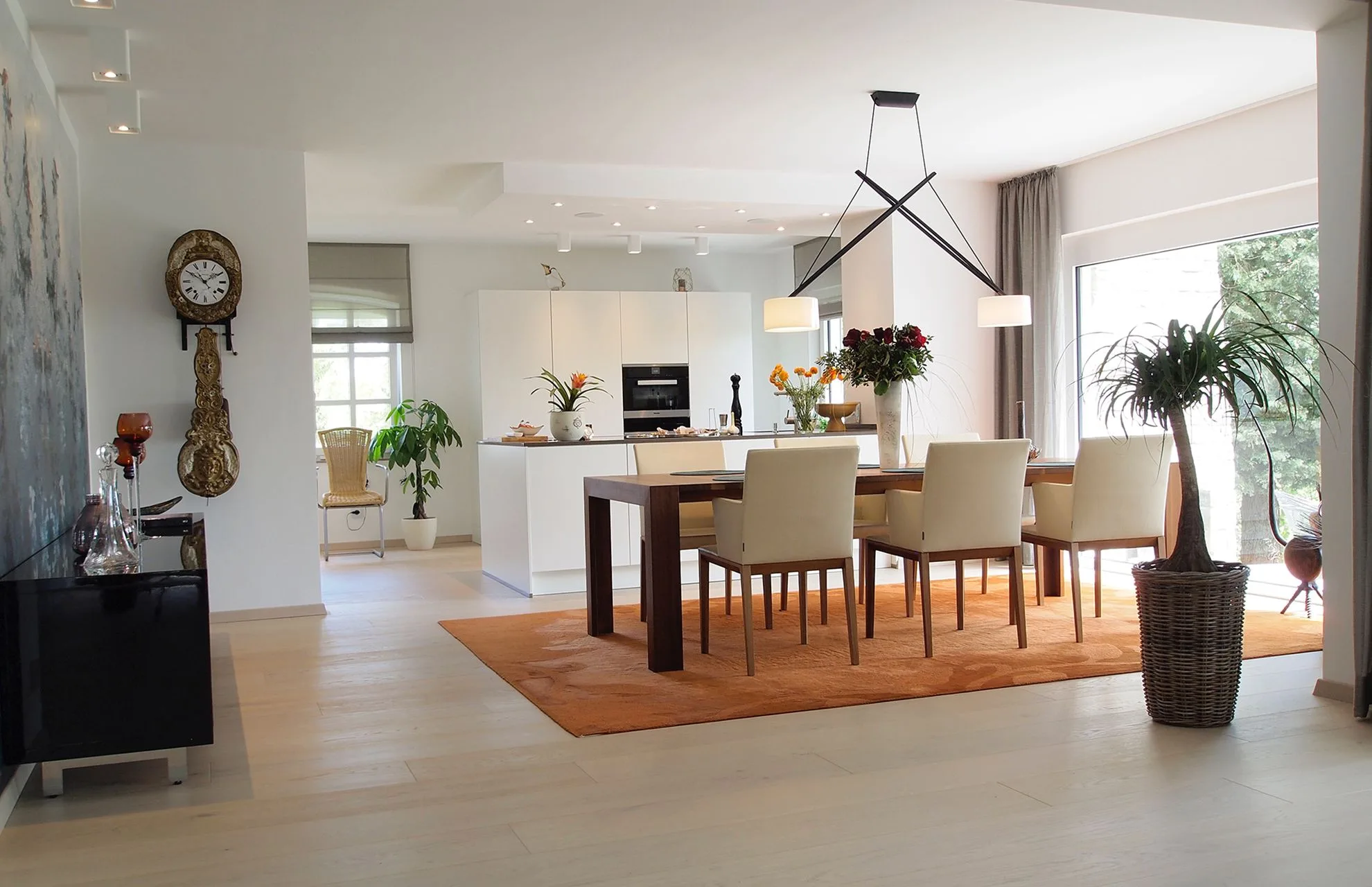 Heller Wohn- und Essbereich mit gestalteten Wandflächen, Holztisch und skulpturaler Pendelleuchte