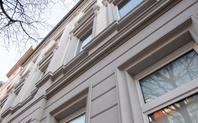 Weiße Fassadengliederung und profilierte Fensterumrahmung