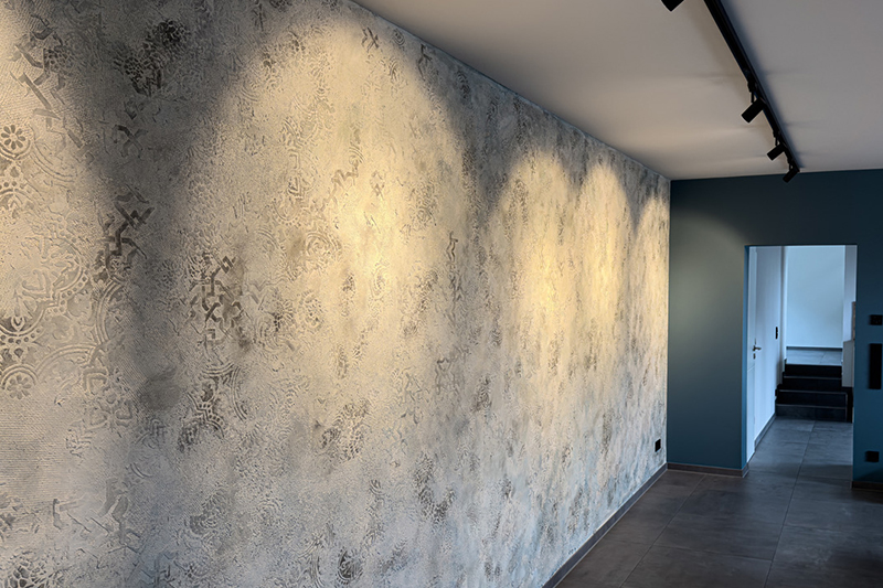 Individuell gestaltete Wand mit feinem Muster und warmem Streiflicht