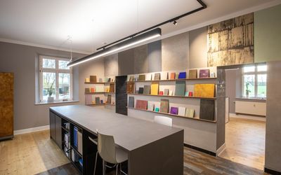 Ausstellungsraum mit Tisch und einer langen Reihe von Materialmustern