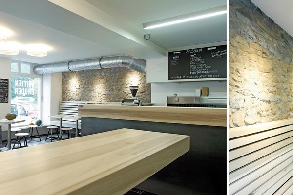 Gastraum mit heller Holztheke und beleuchteter Wand im Frittenbruder