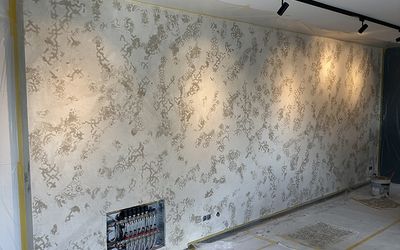 Florales Wandmuster unter gerichteter Deckenbeleuchtung