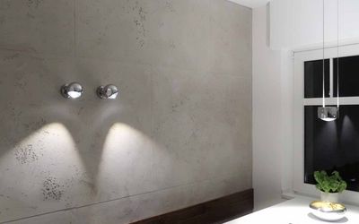 Graue strukturierte Wand mit zwei Wandleuchten