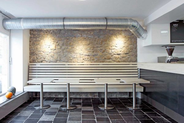 Tische und Sitzbank vor der beleuchteten Motivwand im Frittenbruder