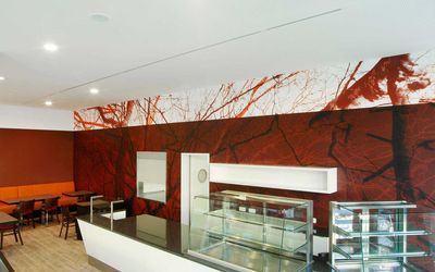 Gastronomieraum mit roter Wandgestaltung und großflächigem Baummotiv